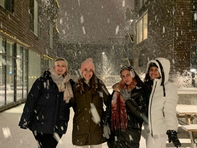 Four exchange students in the snow outside Østfold University College.