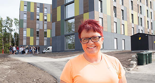 Rita Hirsum Lystad foran de nye studentboligene på Remmen. Foto. 