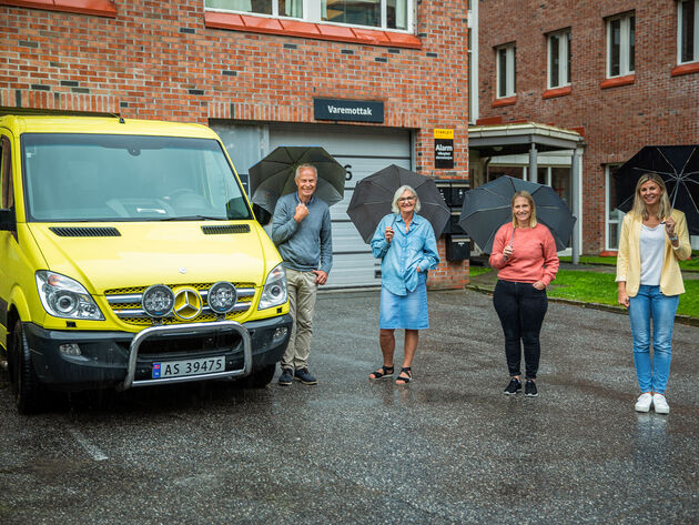 Bildet viser en ambulanse og fire ansatte fra Høgskolen i Østfold.
