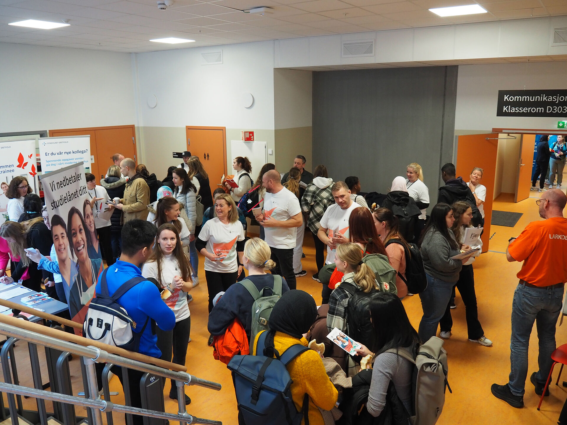 Bildet viser studenter i en korridor på høgskolen i Østfold som besøker en stand på karrieredagen. 