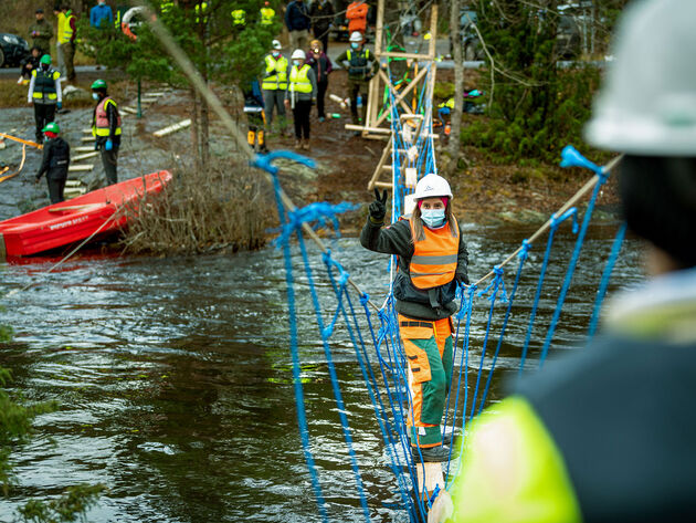 Bildet viser student Natalie Ekelund når hun går over broen hun har laget på Børtevann sammen med medstudenter fra Høgskolen i Østfold.