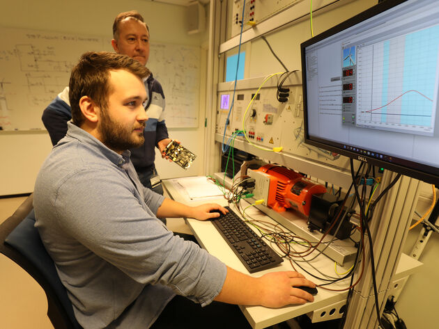 Bildet viser student og forsker i arbeid på elektrolab.