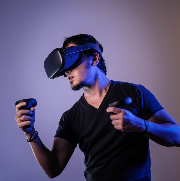 En mann med VR briller som spiller et VR spill. 