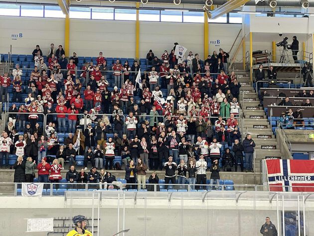 Publikum sitter på tribunen i en ishockeyhall med norske flagg.