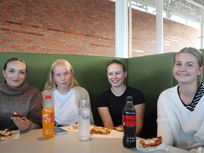Bilde av fire studenter som sitter samlet og spiser.