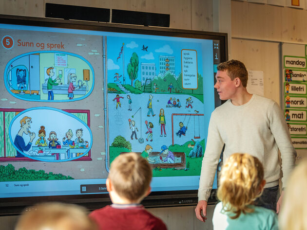 Bildet viser lærerstudent som underviser skolebarn via digital tavle.