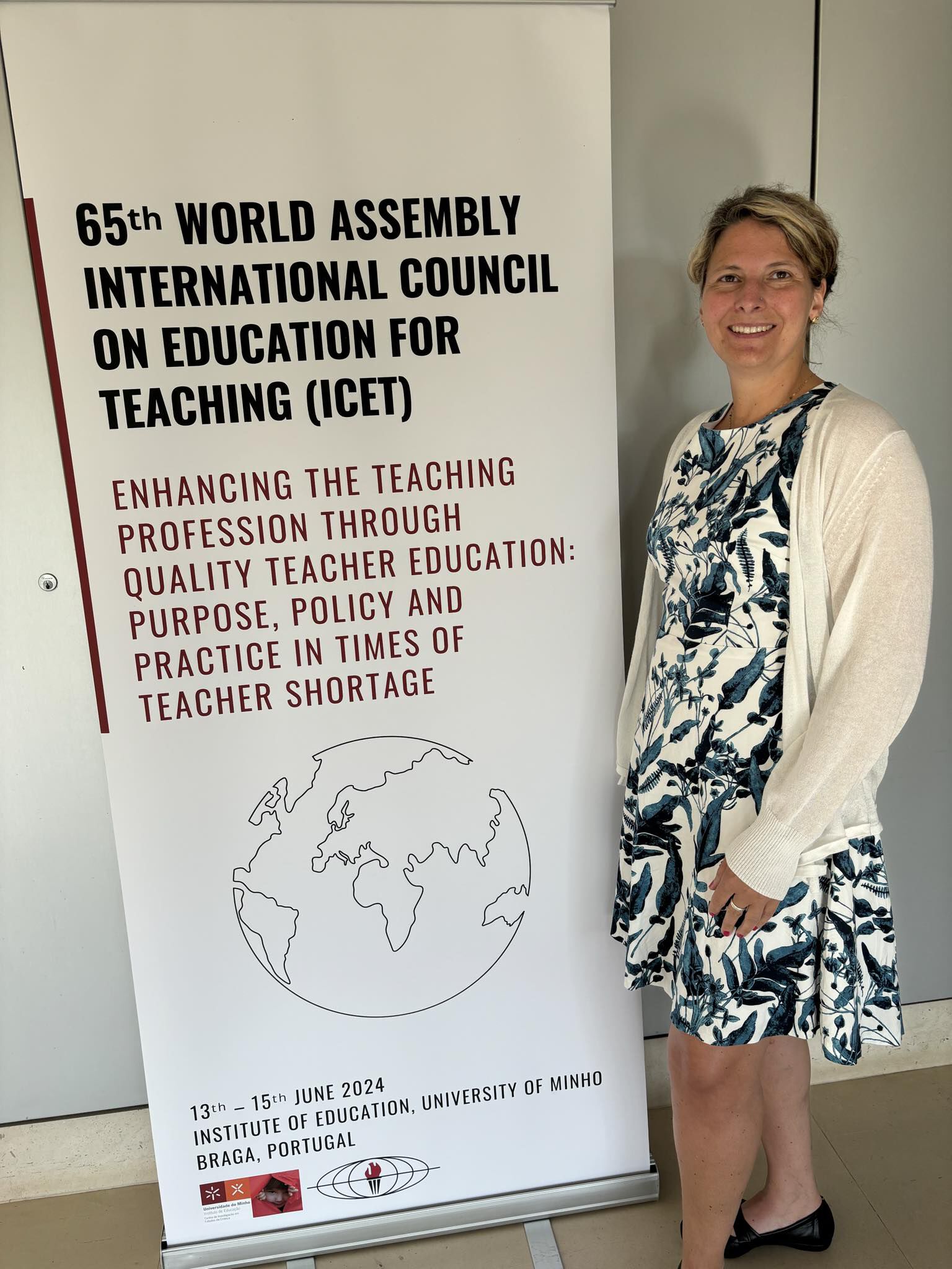 Ilka Nagel in front of a poster for the ICET conference.