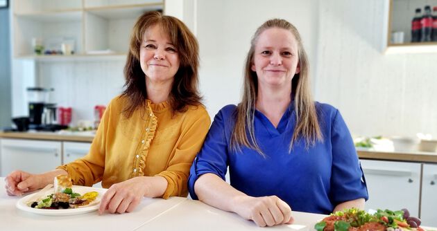 Bildet viser Solveig Toft, som har på seg en gul bluse, og Gunhild Bjørnstad Brænne, som har på seg en blå bluse. Begge sitter ved et bord. 