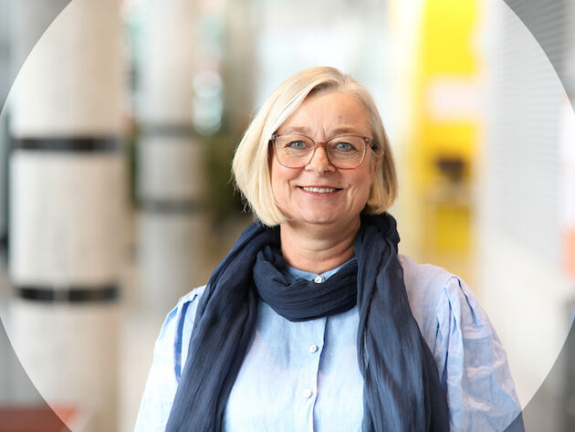 Portrettfoto av forsker Gitte Motzfeldt  inne på høgskolens campus i Halden. 